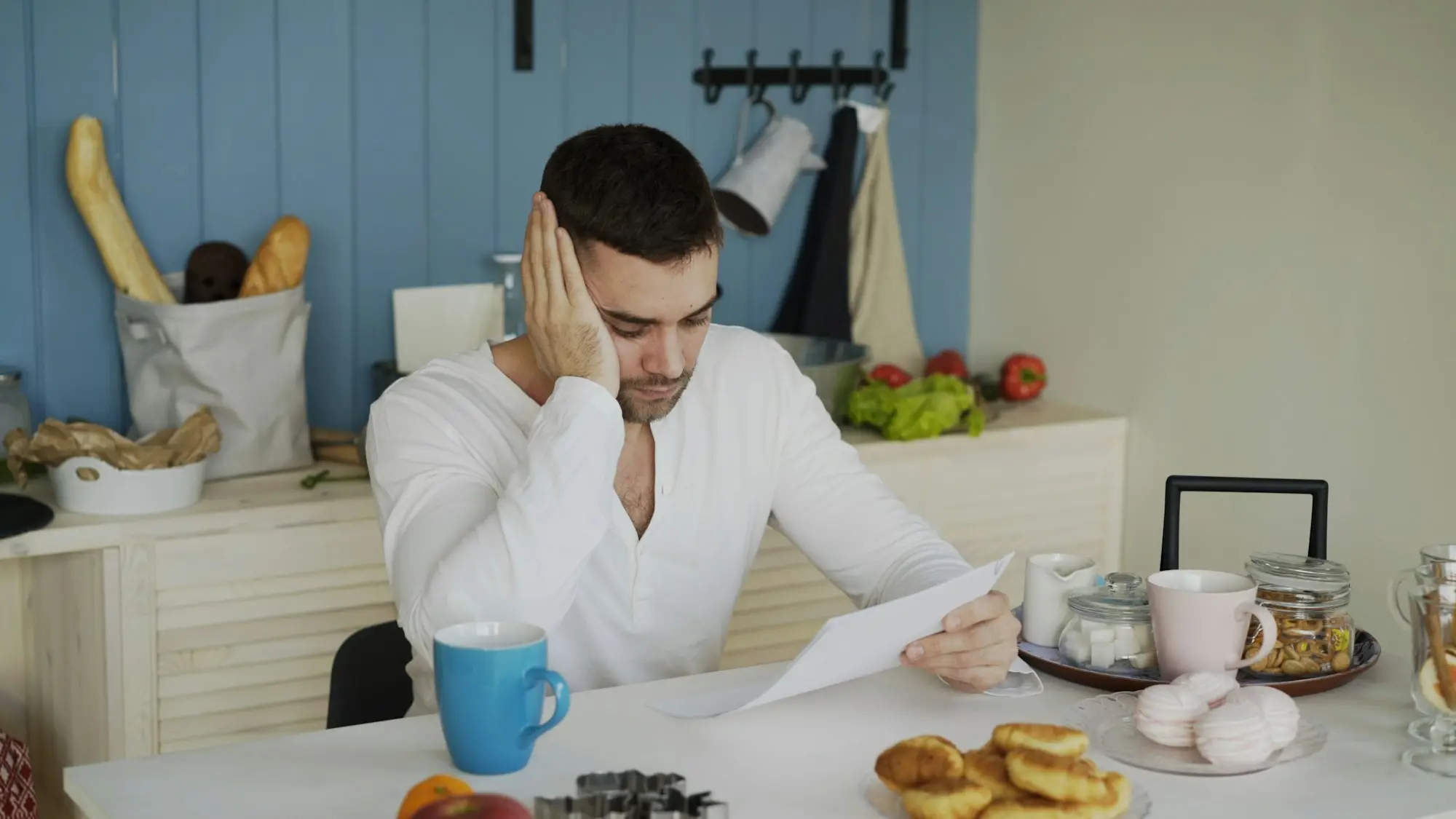 Business owner reading a letter at the kitchen table with a coffee