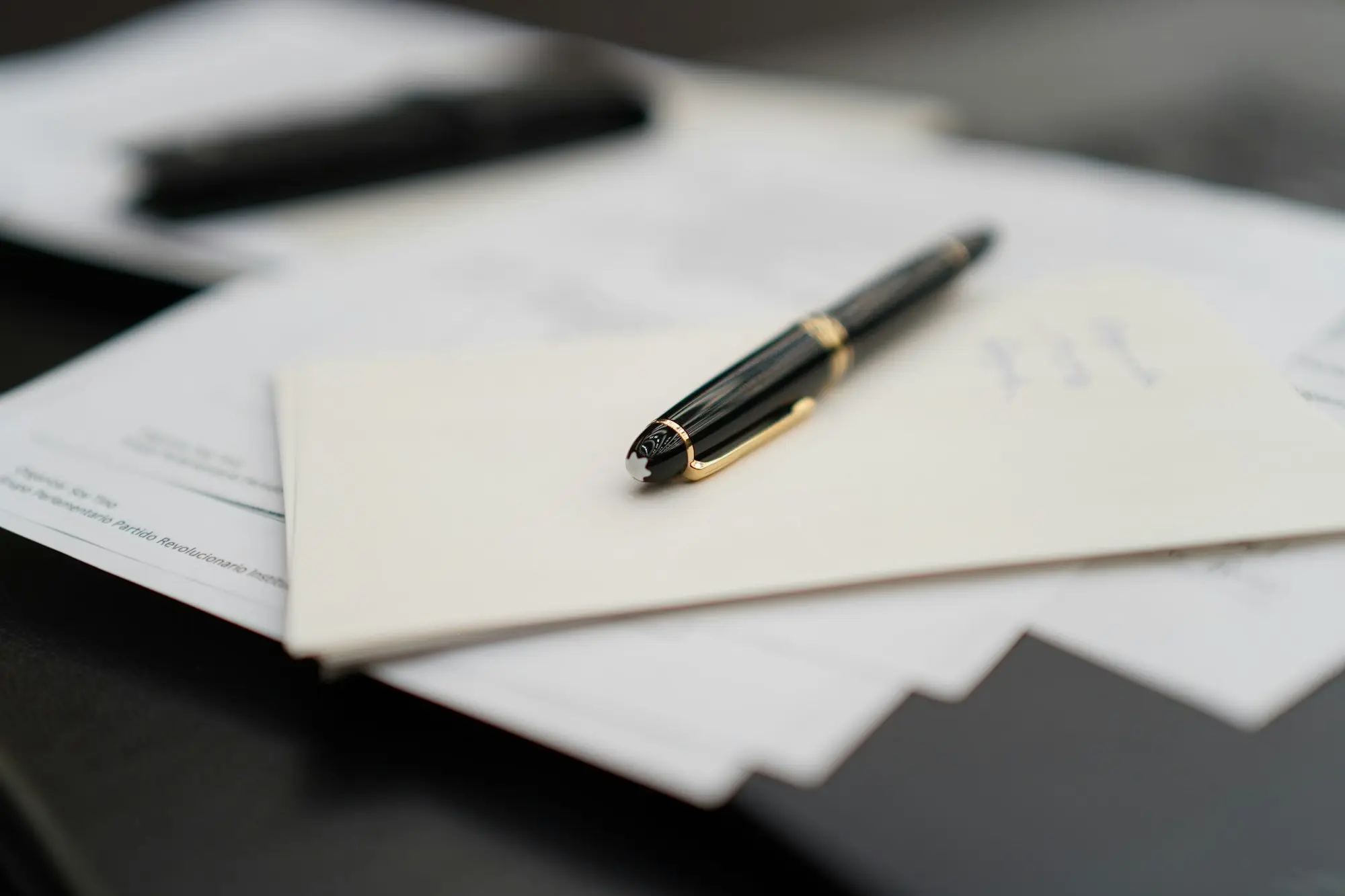 Fountain pen resting on a stack of business documents